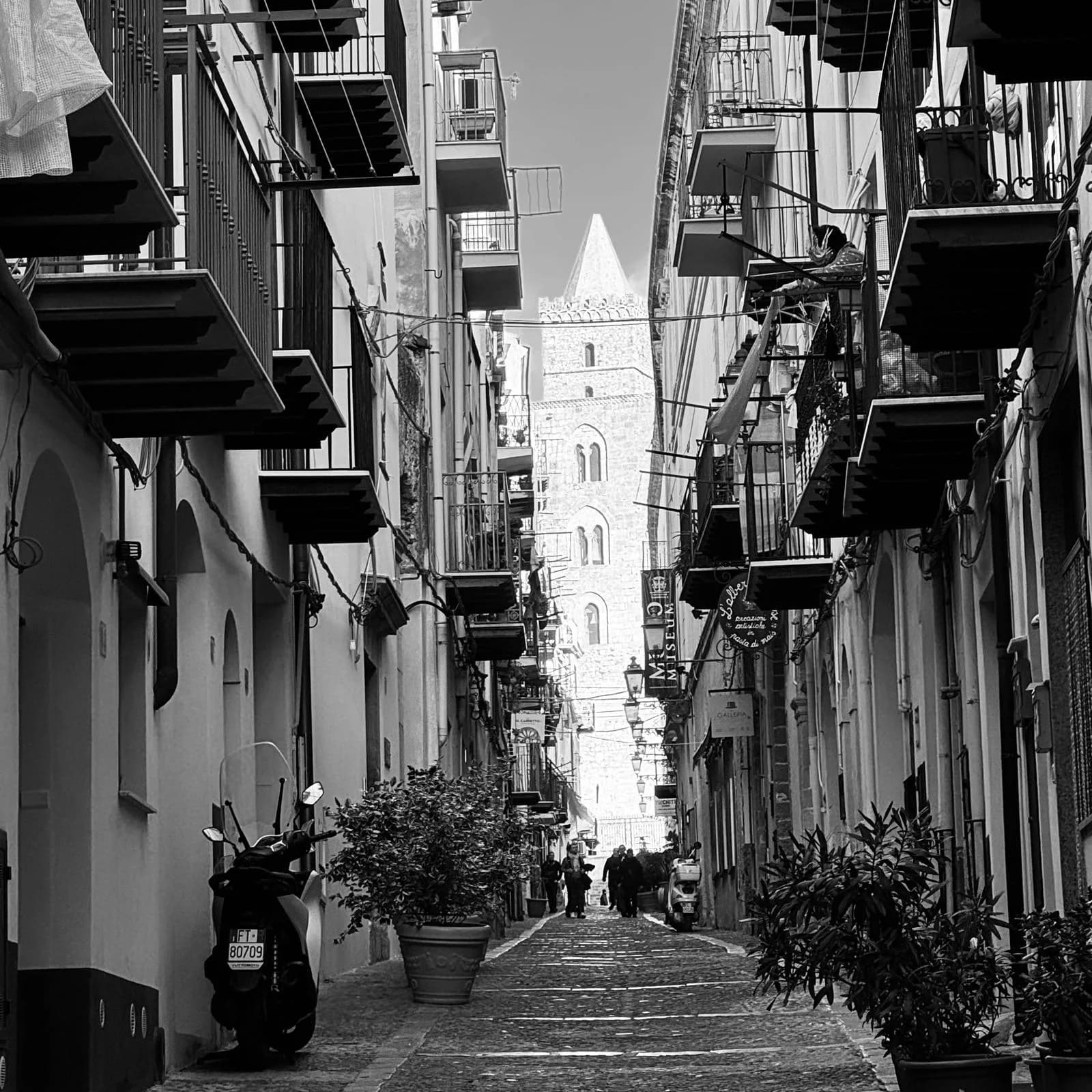 Cobbled lane in Cefalu old town with cathedral tower in the distance