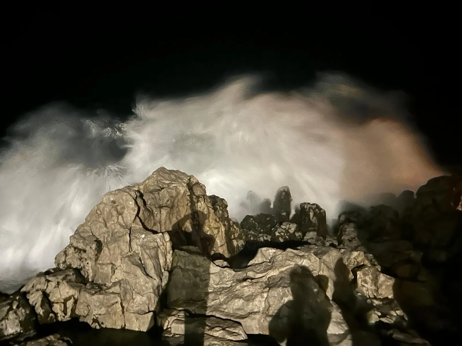 Waves crashing against rocks on the Cefalù coast at night