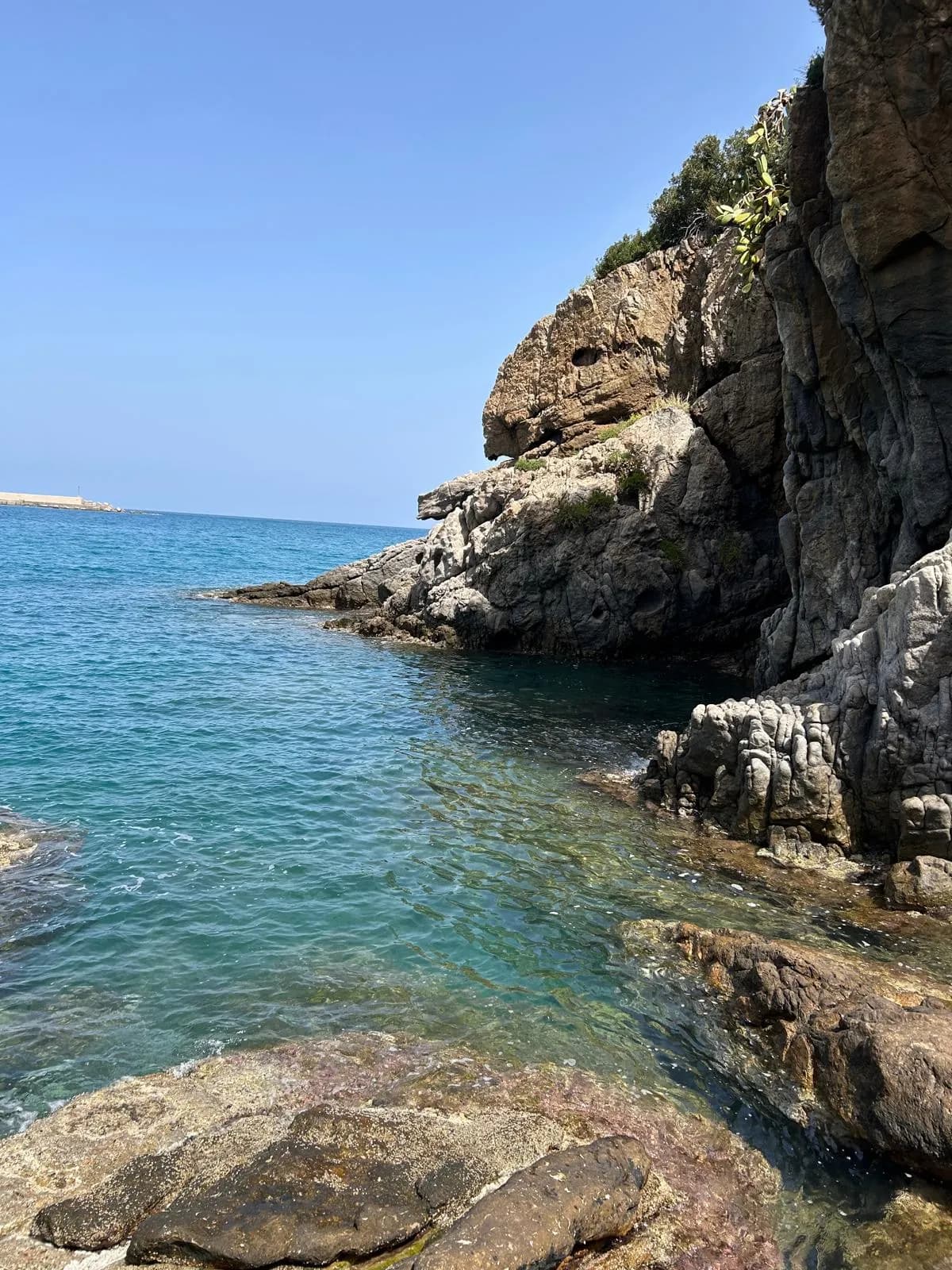 Crystal clear water and rocky cliff along the Cefalù coast