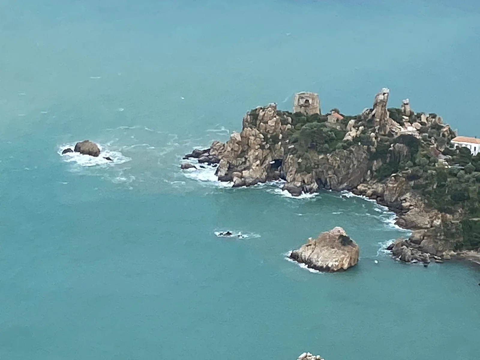 Aerial view of the Kalura watchtower headland and turquoise sea from La Rocca