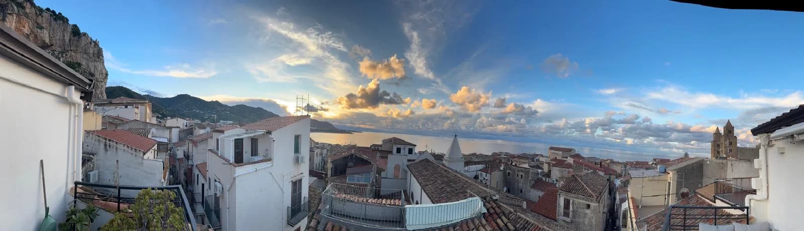 Golden sunset over the sea and Cefalù rooftops seen from above