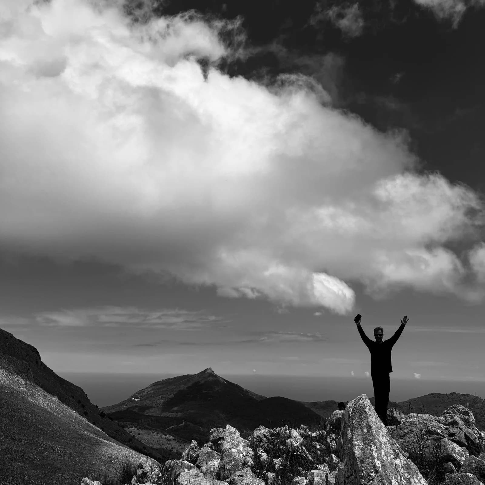 Hiker celebrating on a Madonie mountain summit above the sea