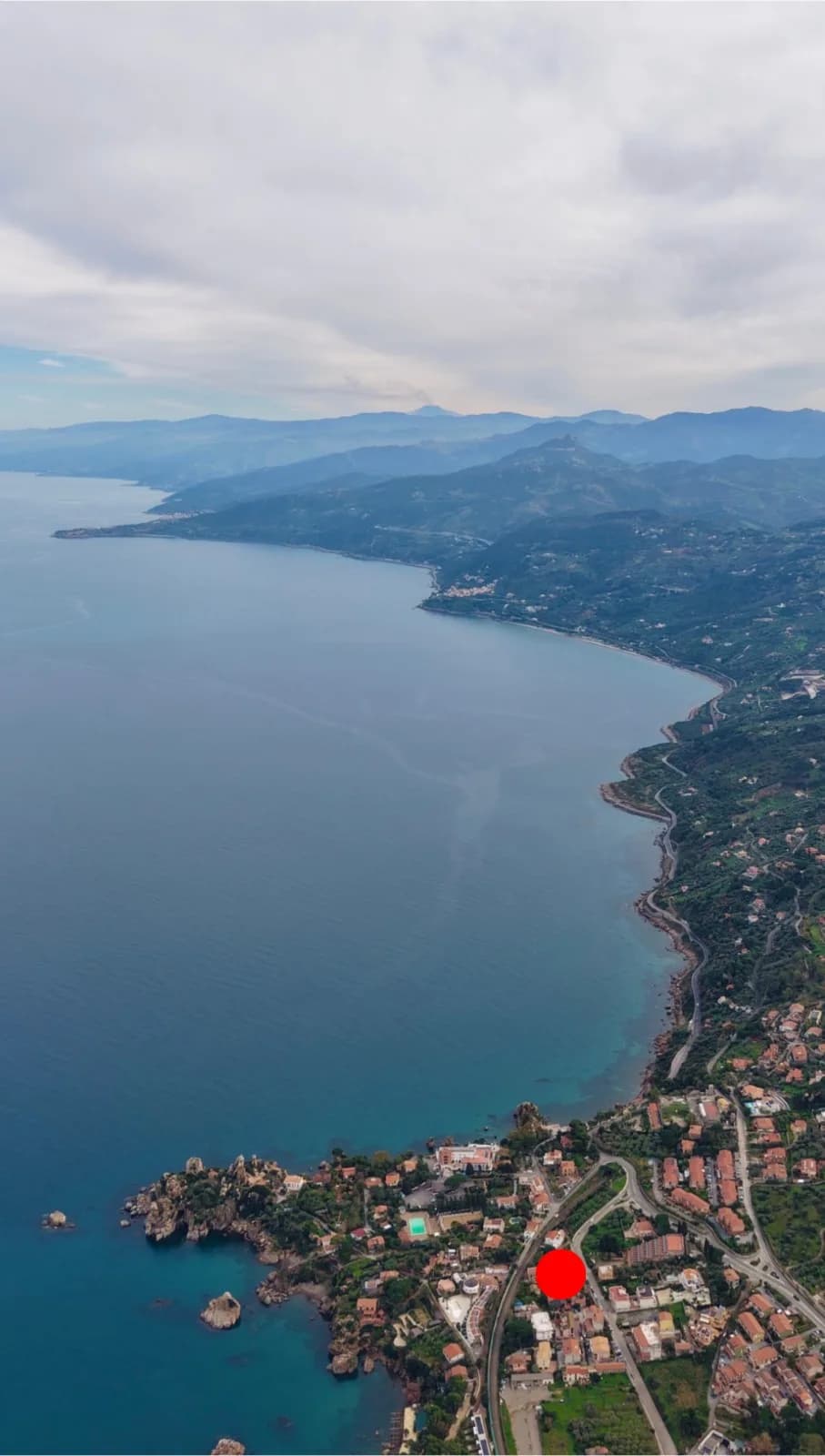 Aerial view along the coast east of Cefalù toward the Madonie mountains, with the property location marked on the shore