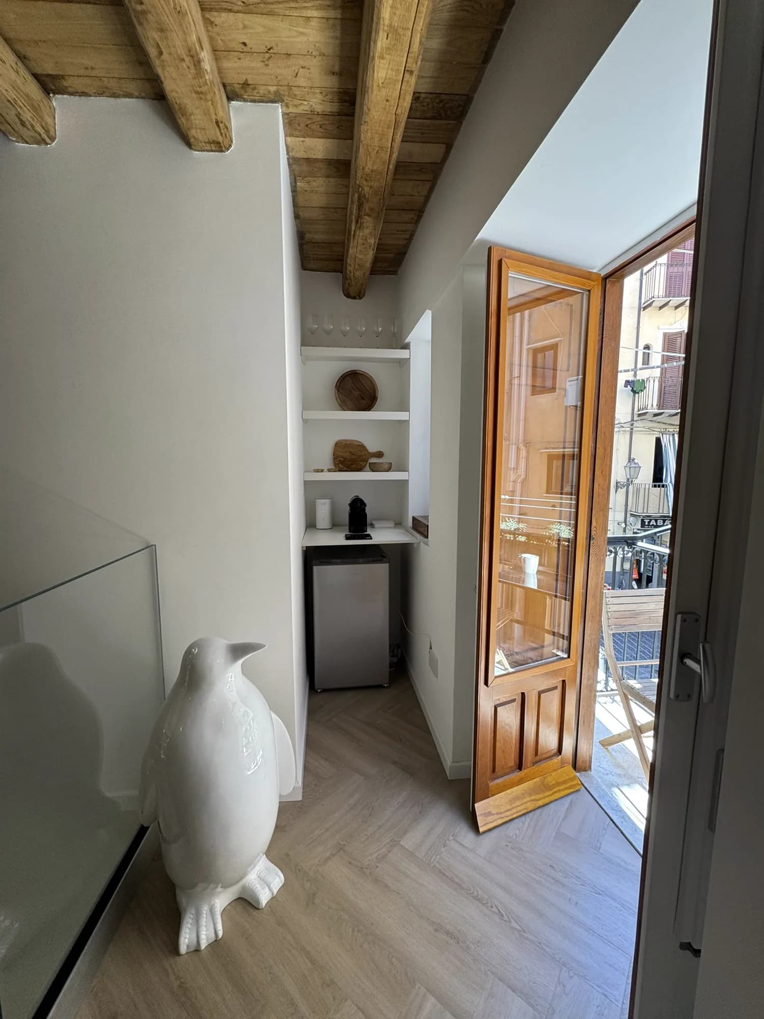 Living room framed by beamed ceilings, opening onto a balcony over the old town