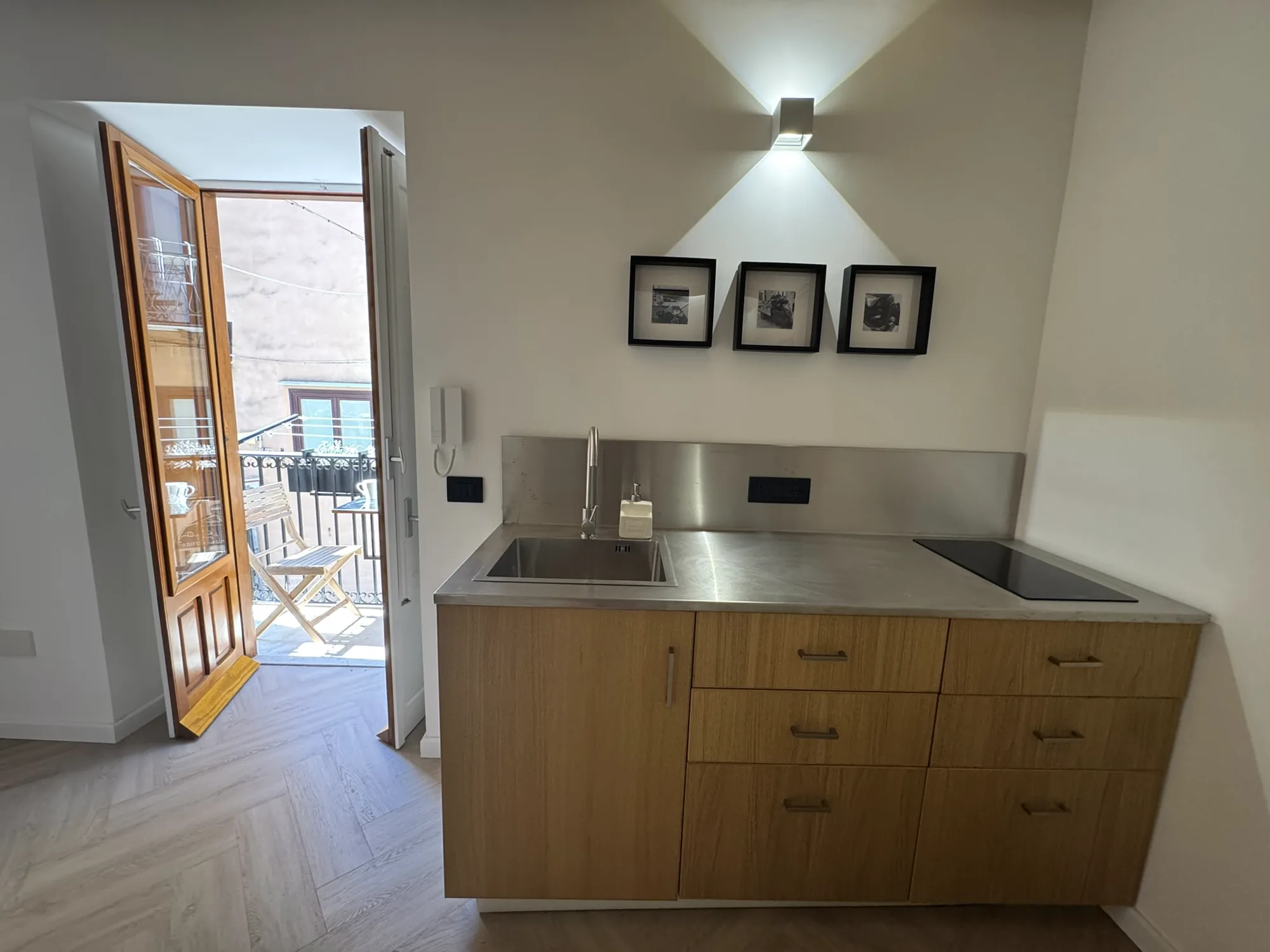 Compact kitchen with timber cabinetry and a stainless-steel worktop