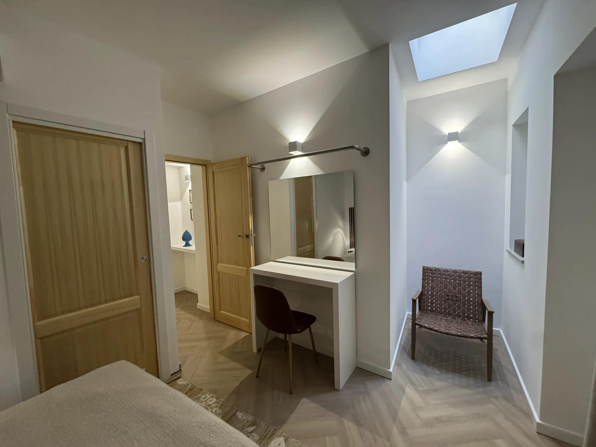 Dressing area with a mirrored console and views through to the bedroom