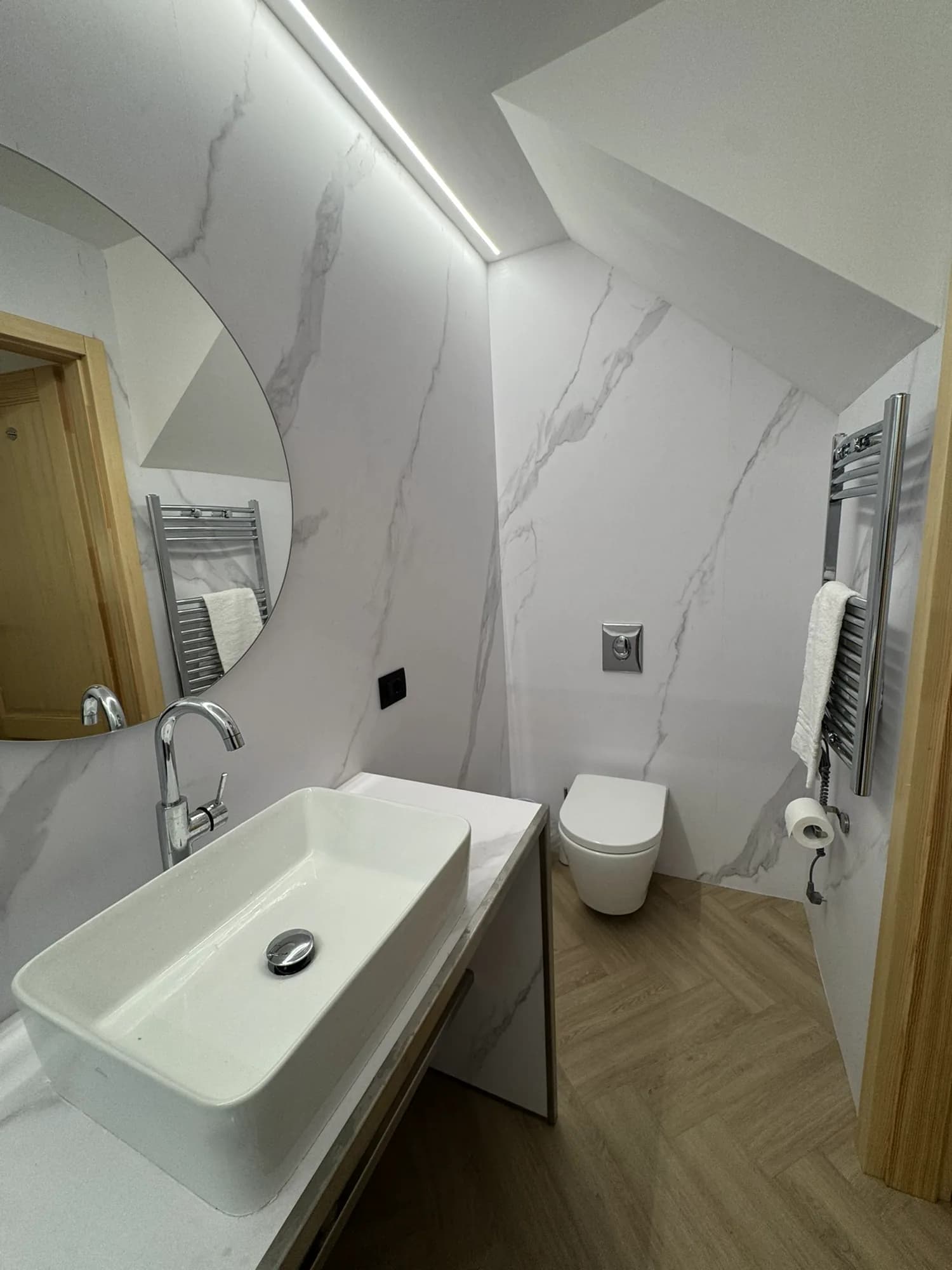 Marble bathroom with a vessel basin, heated towel rail and WC