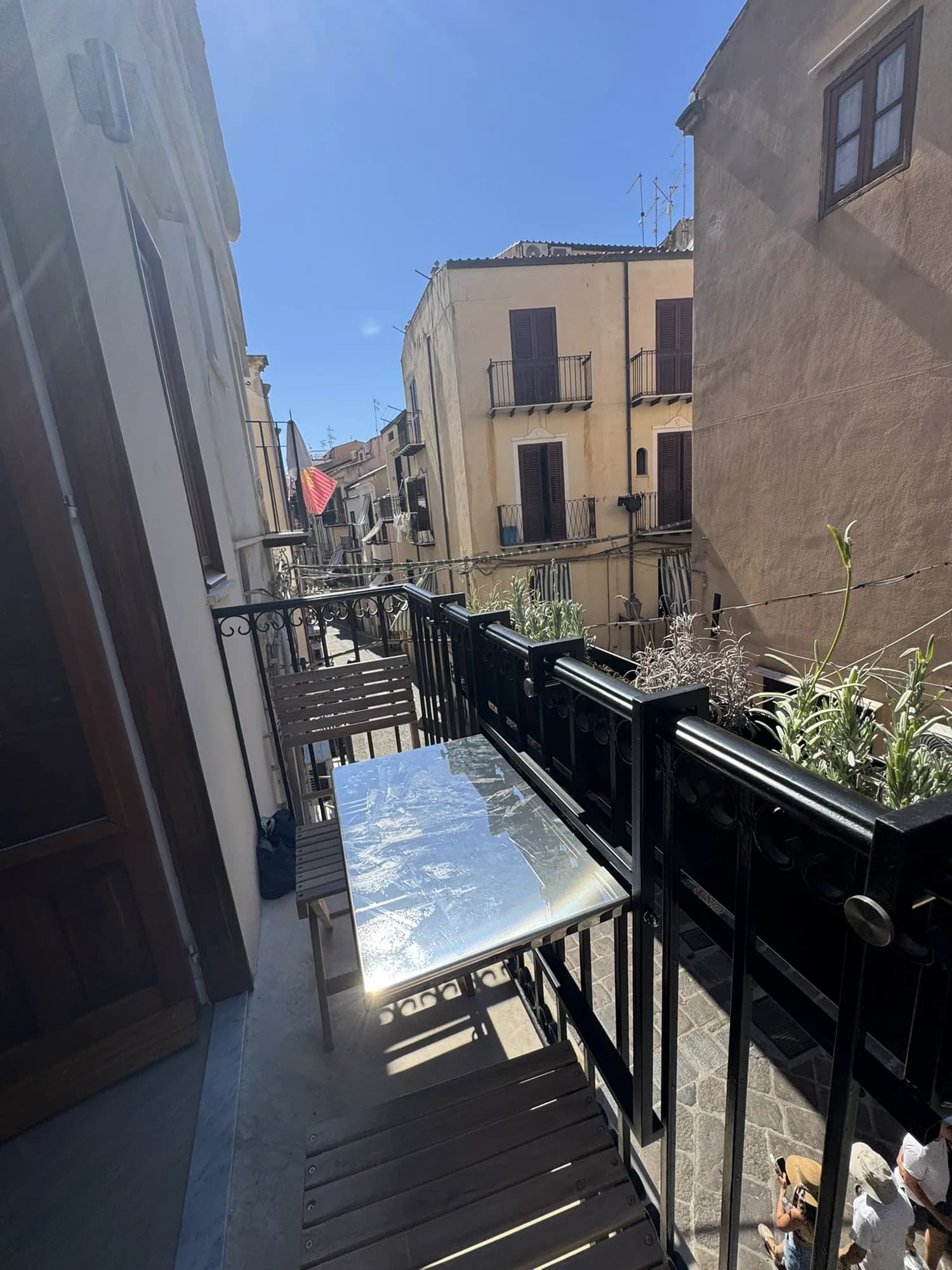 Balcony bistro set overlooking the sunlit lanes of the old town