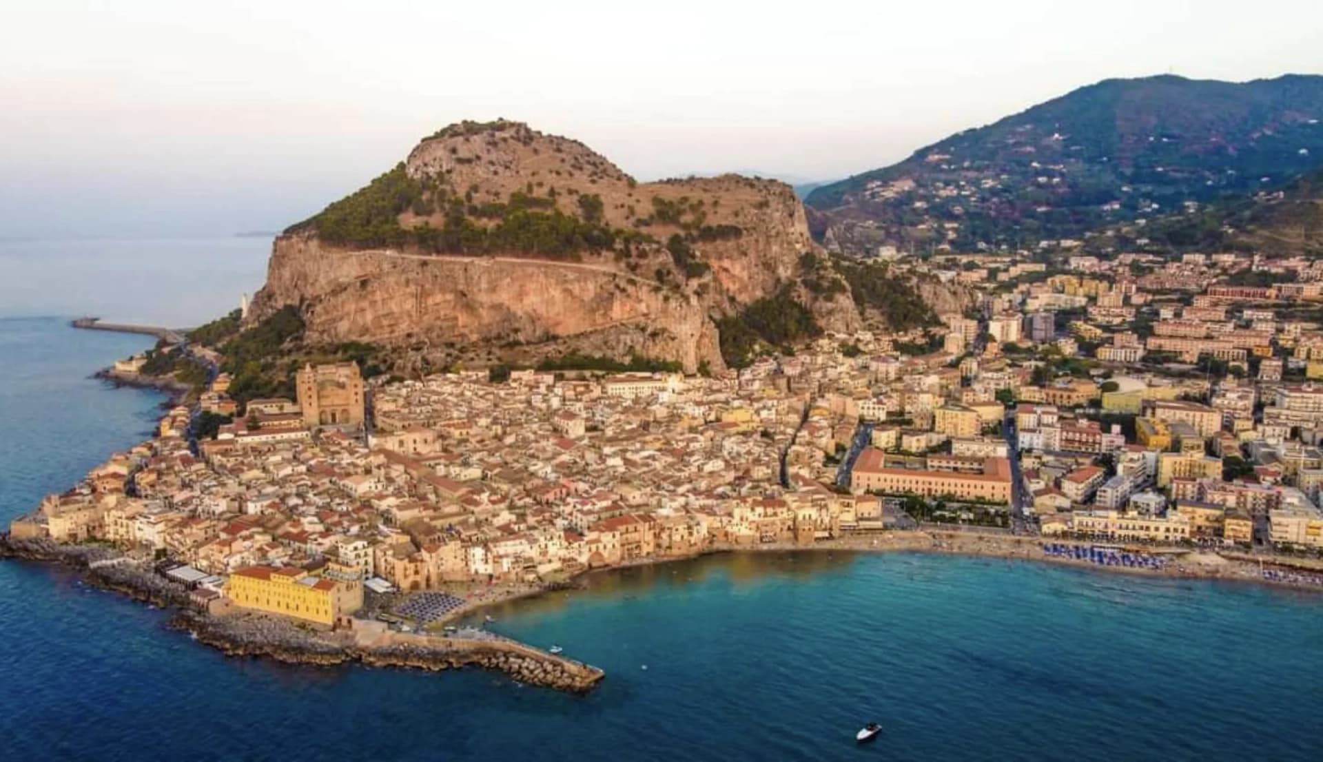 Aerial view of Cefalù old town wrapped around the Rocca and the bay