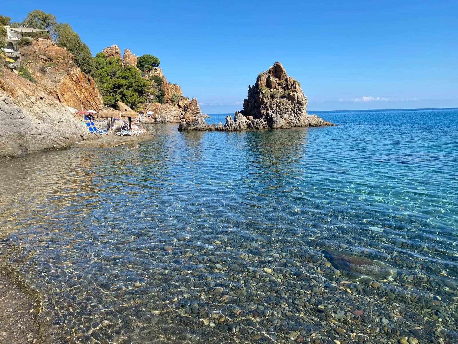 Clear turquoise water and a rocky cove on the coast near Cefalù, Sicily