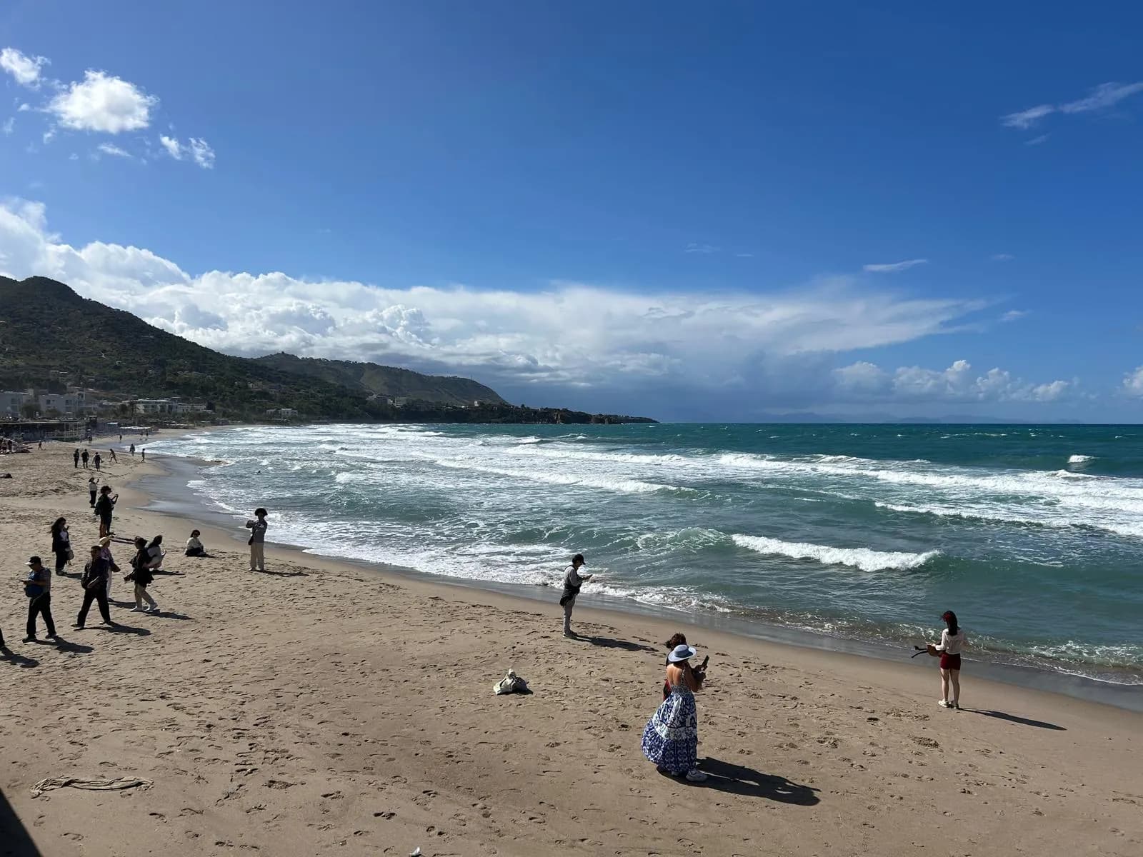 Families on the sandy Lungomare beach with La Rocca in the background