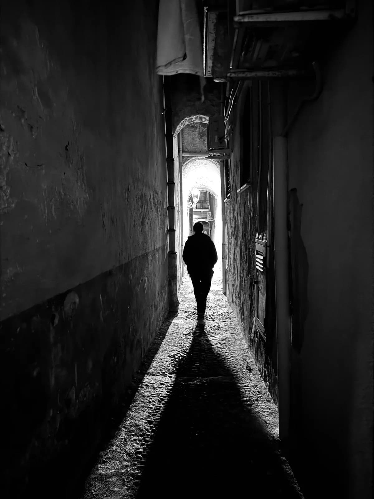 Silhouette in a narrow alley of Cefalù old town