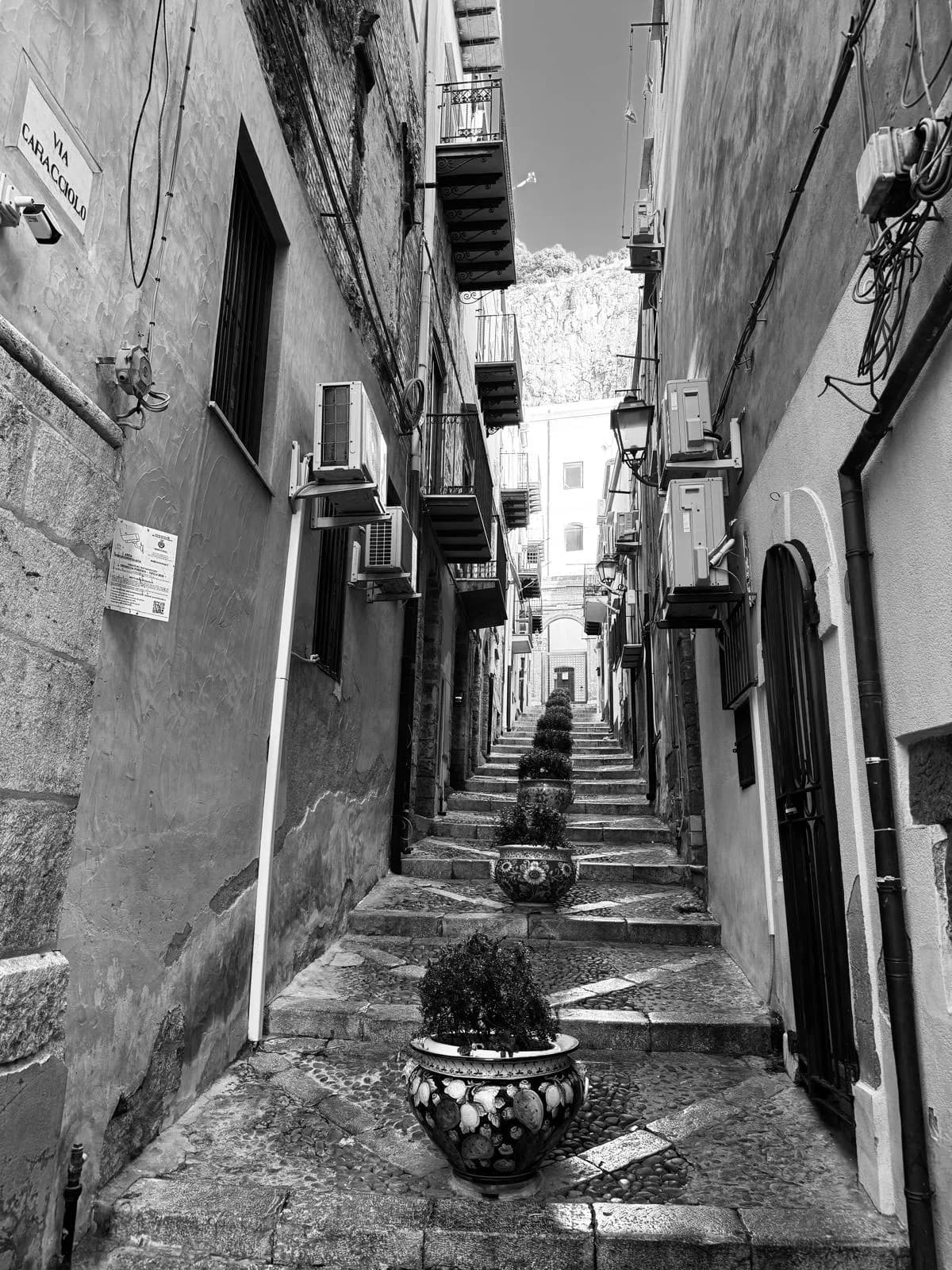 Sunlit lane between stone walls in the old town