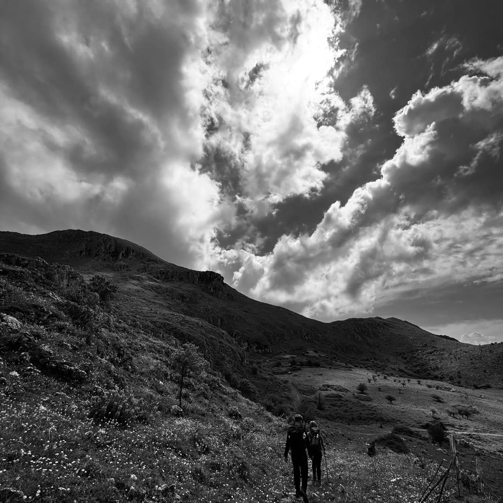 Hikers on a Madonie mountain ridge beneath dramatic clouds