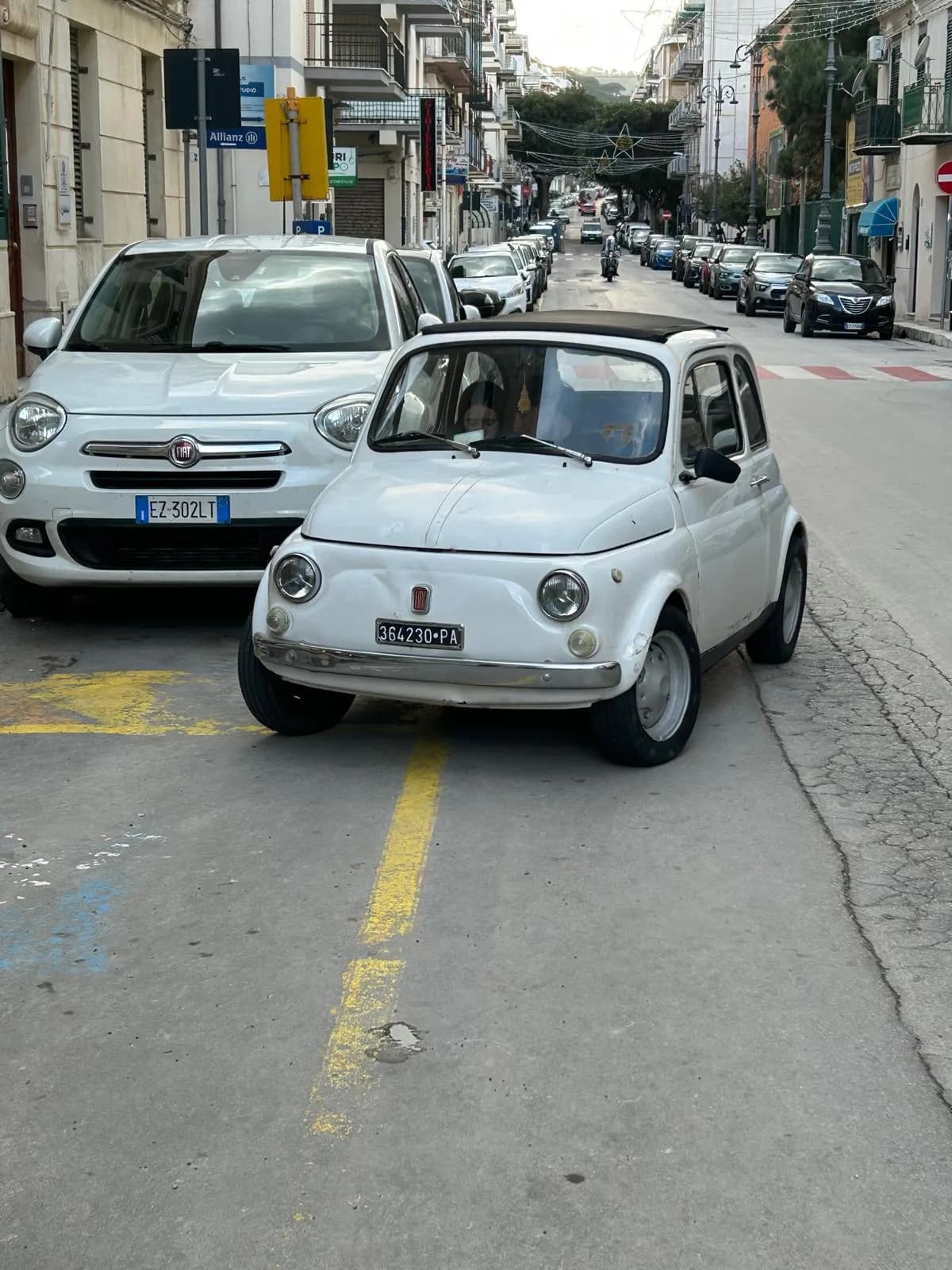 Vintage Fiat 500 parked on a Cefalù street beside its modern counterpart
